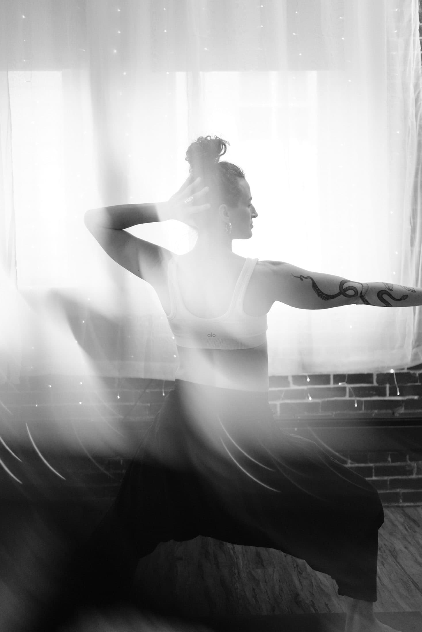 Black-and-white long exposure of a practitioner mid-movement, fabric blurred across the frame