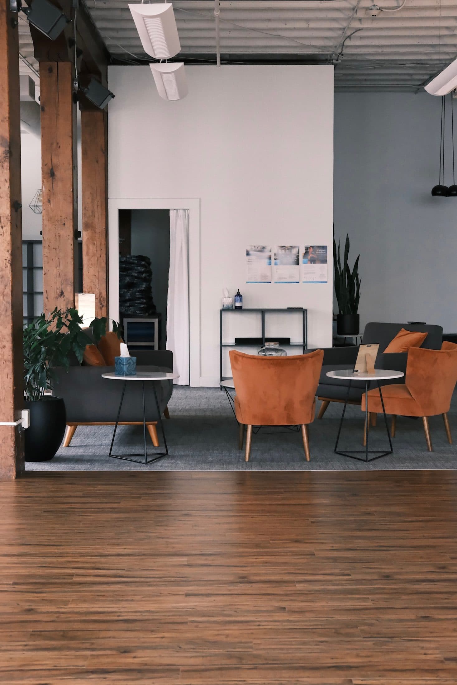 View across the wood floor toward the lounge and its rust velvet chairs
